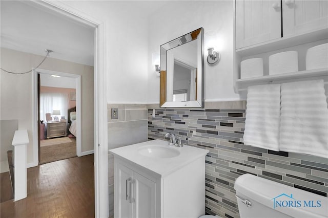 2923 Powhattan Pkwy, Toledo, OH 43606 - half bath with wood finished floors, toilet, tile walls, and vanity