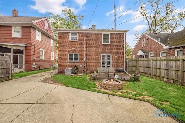 2923 Powhattan Pkwy, Toledo, OH 43606 - back of house featuring brick siding, a fire pit, a patio area, central AC, and driveway
