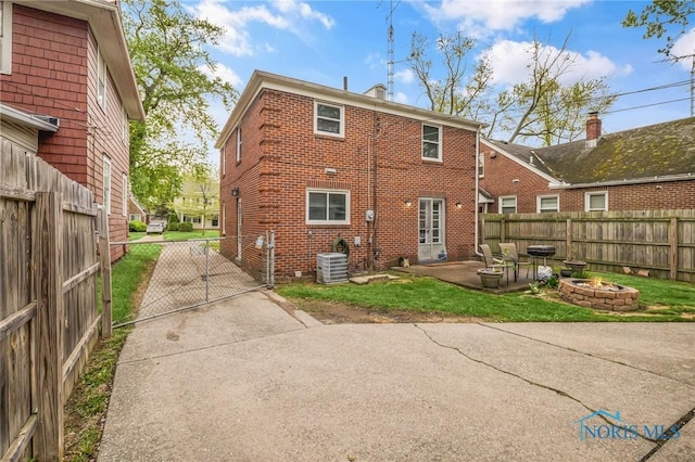 2923 Powhattan Pkwy, Toledo, OH 43606 - back of property featuring an outdoor fire pit, brick siding, a patio, and a fenced backyard