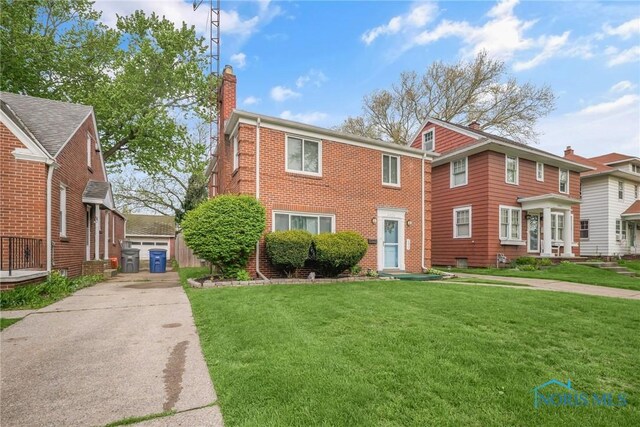 2923 Powhattan Pkwy, Toledo, OH 43606 - view of front facade featuring a chimney, a front yard, and brick siding