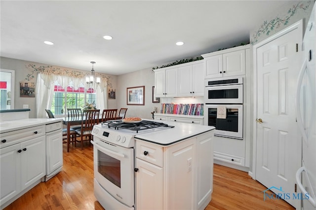 3145 Shoreland Ave, Toledo, OH 43611 - kitchen with white appliances, a chandelier, light wood finished floors, white cabinets, and recessed lighting