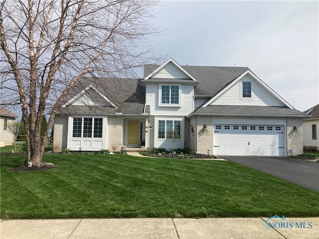traditional-style home with a front yard, driveway, and a shingled roof