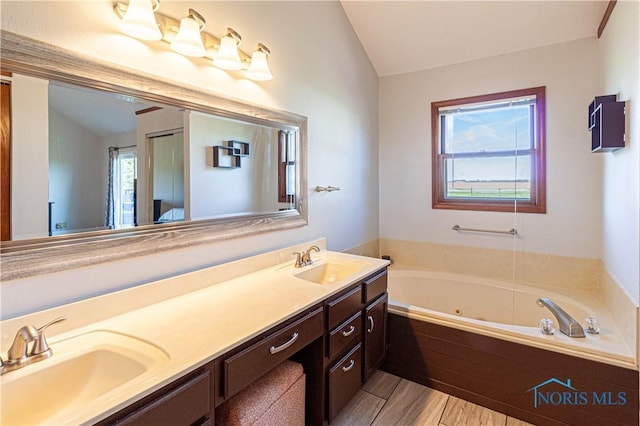 556 S Lathrop Rd, Swanton, OH 43558 - full bath featuring double vanity, a sink, a jetted tub, and lofted ceiling