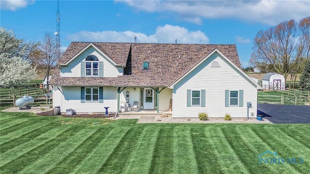 556 S Lathrop Rd, Swanton, OH 43558 - view of front of property with an outdoor structure, covered porch, fence, a storage shed, and a front yard
