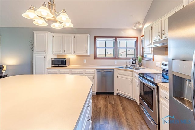 556 S Lathrop Rd, Swanton, OH 43558 - kitchen with a sink, stainless steel appliances, under cabinet range hood, a notable chandelier, and white cabinetry