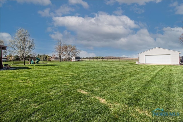 556 S Lathrop Rd, Swanton, OH 43558 - view of yard with fence, a detached garage, an outbuilding, and a playground