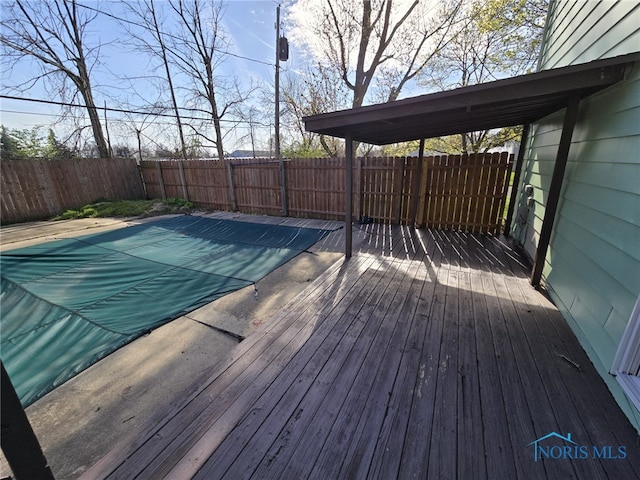 view of swimming pool featuring a wooden deck and a fenced backyard