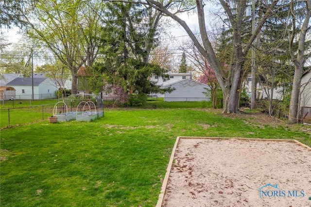 view of yard featuring fence and a vegetable garden