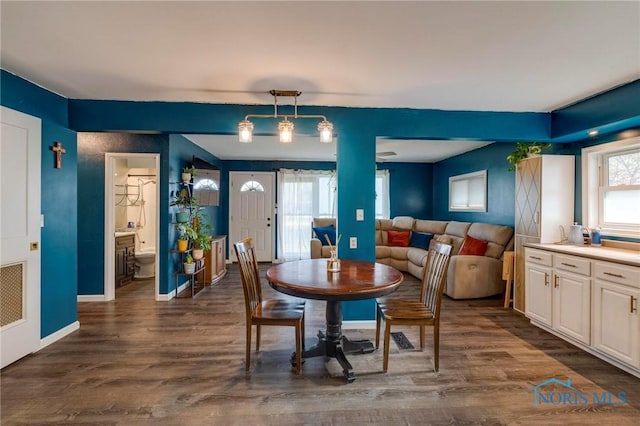 dining room featuring dark wood-style flooring and baseboards