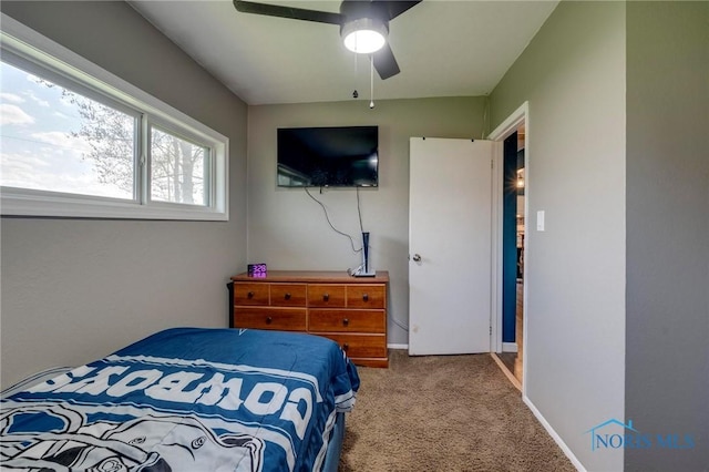 carpeted bedroom with a ceiling fan and baseboards