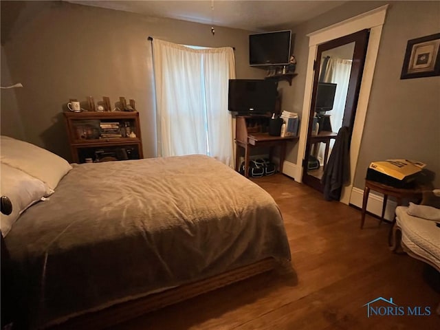 825 S Clinton St, Defiance, OH 43512 - bedroom with baseboard heating and wood finished floors