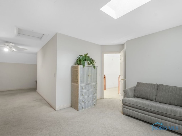 living area featuring baseboards, attic access, and carpet floors