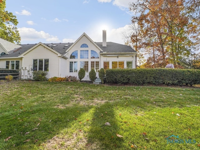 rear view of property with a chimney, fence, and a lawn