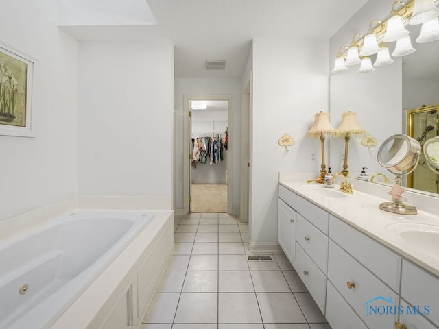 full bath featuring a sink, a shower stall, a bath, double vanity, and tile patterned flooring