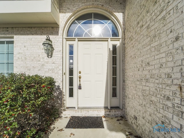 doorway to property featuring brick siding