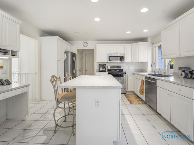 kitchen with appliances with stainless steel finishes, a kitchen bar, and white cabinets
