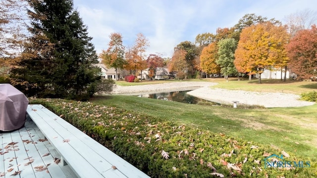 surrounding community featuring a lawn and a water view