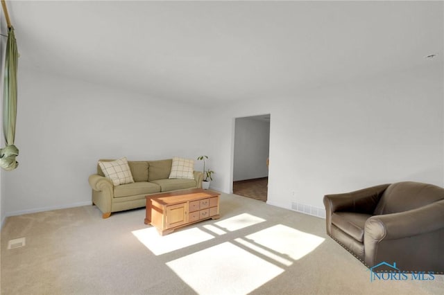 living room featuring baseboards, carpet, and visible vents