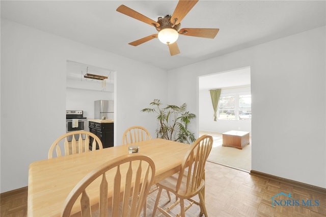dining area with a ceiling fan and baseboards