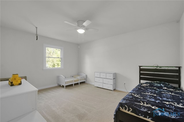 bedroom featuring baseboards, light carpet, and a ceiling fan