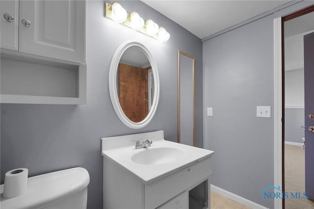 bathroom with vanity, baseboards, and toilet