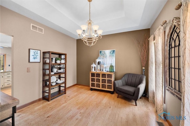 6170 S Winding Way, Swanton, OH 43558 - living area with a notable chandelier, a raised ceiling, visible vents, light wood-style flooring, and baseboards