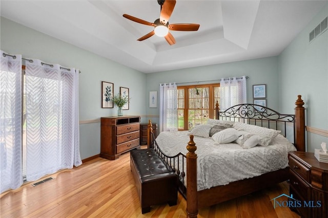 6170 S Winding Way, Swanton, OH 43558 - bedroom featuring ceiling fan, a raised ceiling, light wood-type flooring, and visible vents