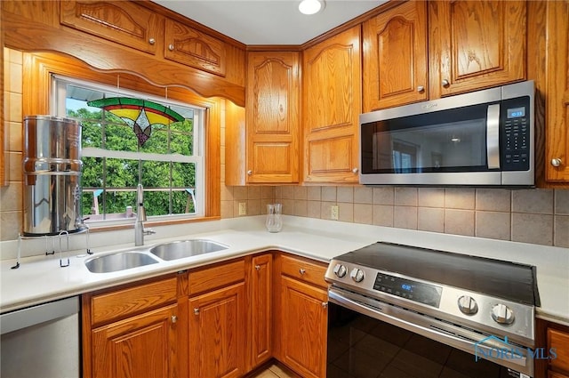 864 Cherry Ln, Waterville, OH 43566 - kitchen featuring appliances with stainless steel finishes, a sink, light countertops, and brown cabinetry