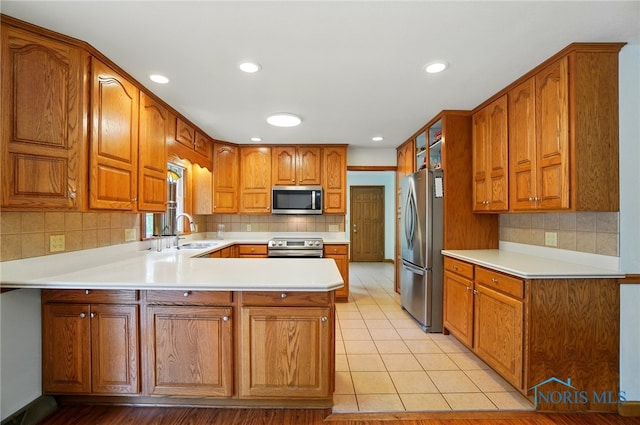864 Cherry Ln, Waterville, OH 43566 - kitchen featuring stainless steel appliances, a sink, a peninsula, brown cabinets, and recessed lighting