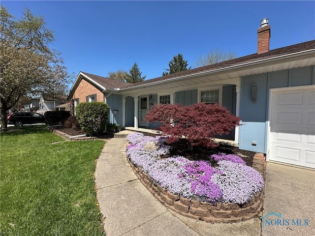 864 Cherry Ln, Waterville, OH 43566 - view of front of house with a chimney, a front yard, board and batten siding, and an attached garage
