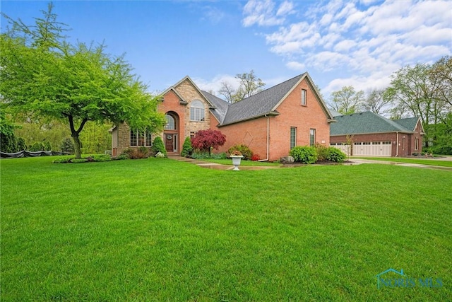 traditional-style home featuring a front lawn, brick siding, and a garage