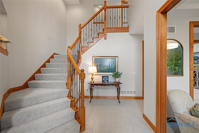 stairs with baseboards and tile patterned floors