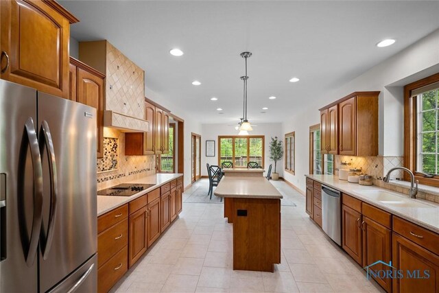 kitchen featuring appliances with stainless steel finishes, a center island, a sink, recessed lighting, and tasteful backsplash