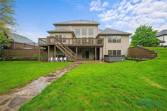 back of house with a hot tub, a wooden deck, stairs, and a patio area