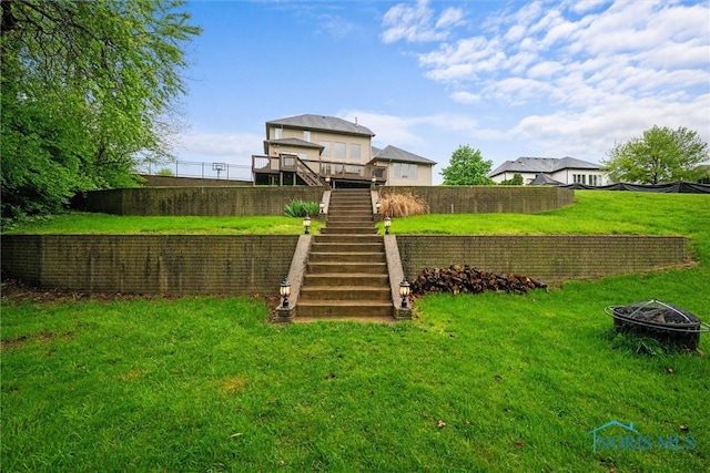 view of yard with an outdoor fire pit and stairs