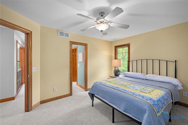 bedroom featuring light colored carpet, baseboards, and ceiling fan