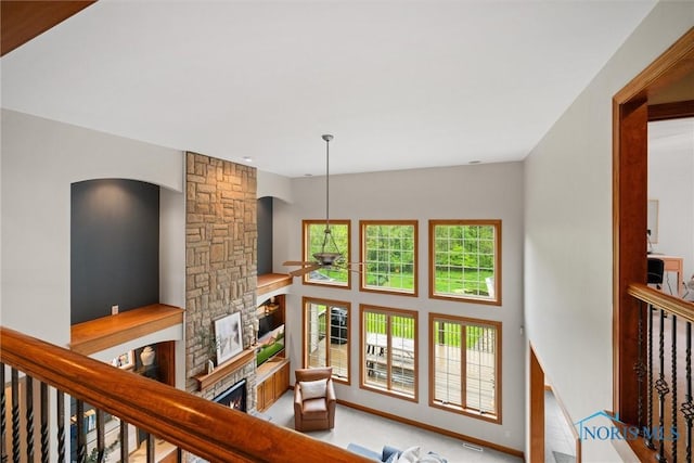 living area featuring a ceiling fan, a fireplace, and arched walkways