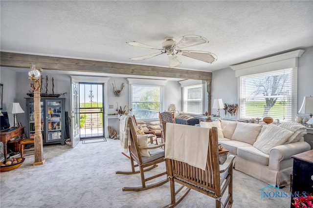 living room featuring light carpet, a textured ceiling, and ceiling fan