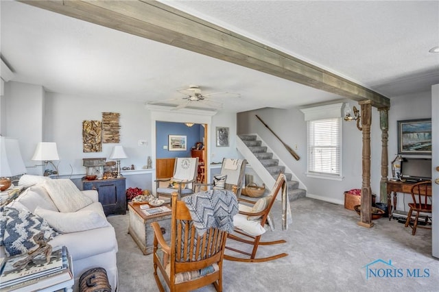 living room featuring ceiling fan, light carpet, and stairs