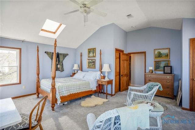 bedroom with vaulted ceiling with skylight, light carpet, ceiling fan, baseboards, and visible vents