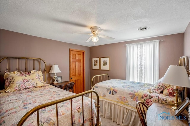 bedroom featuring visible vents, ceiling fan, and a textured ceiling