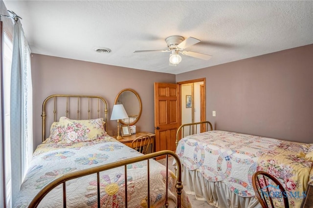 bedroom featuring visible vents, a ceiling fan, a textured ceiling, and carpet floors