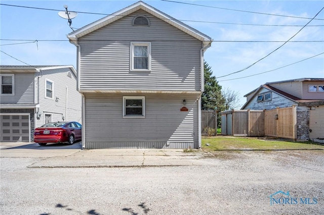 view of front of house featuring driveway and fence