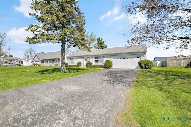 14384 Georgetown Dr, Bowling Green, OH 43402 - ranch-style home featuring fence, aphalt driveway, a front lawn, and a garage