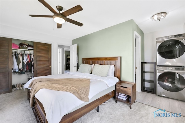 14384 Georgetown Dr, Bowling Green, OH 43402 - bedroom featuring stacked washer and dryer, a closet, and a ceiling fan