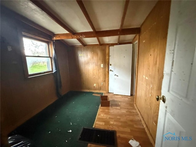 unfurnished room featuring wood walls and wood finished floors