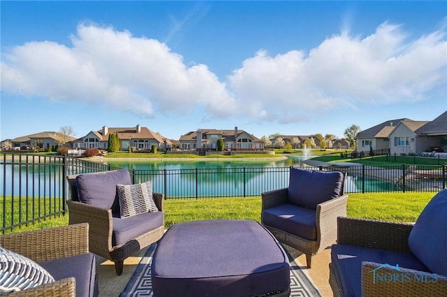 view of patio / terrace with a residential view, fence, and a water view
