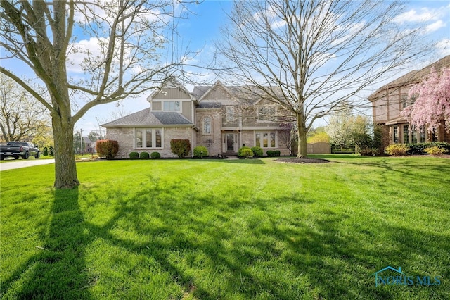 traditional home with a front yard and brick siding