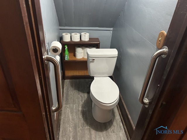 bathroom featuring toilet, wood finished floors, and baseboards
