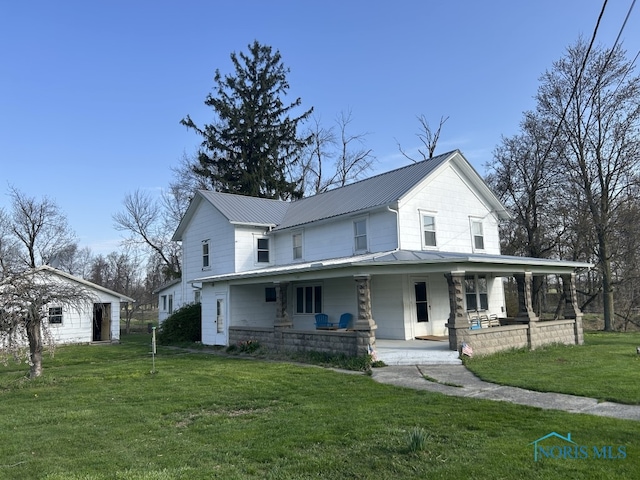 farmhouse featuring covered porch, metal roof, and a front lawn